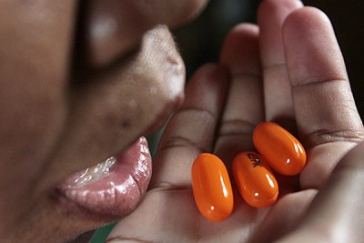 A woman living with HIV takes her daily dosage of the life-saving drugs