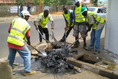 Youths participate in a roadside clean-up.