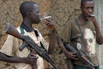 Young militia fighters stand guard outside their leaders hut in Democratic Republic of Congo's  Ituri region.