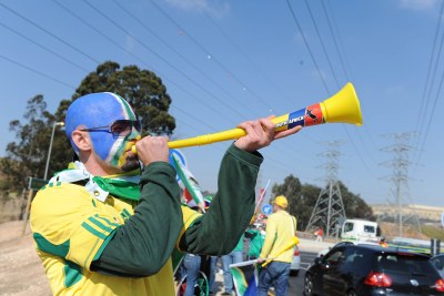 A painted soccer fan blows a vuvuzela as he walks to the first match of the 2010 FIFA World Cup, between host South Africa and Mexico, played in Johannesburg.