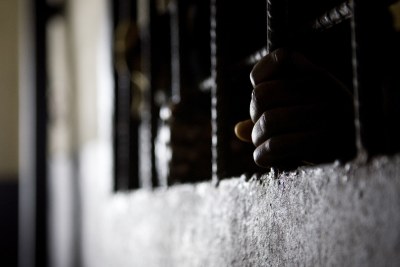 Prisoner's hands on the bars in his cell (file photo): Inhumane conditions in South African prisons are making the department of correctional service vulnerable to legal action, MPs say.