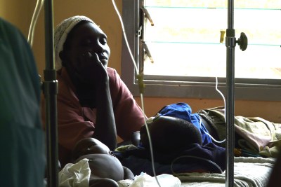 A worried mother watches over her children who contracted malaria.
