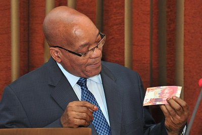 President Jacob Zuma holds the new currency bearing the image of former president Nelson Mandela.