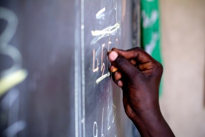 A student writes on a blackboard (file photo).
