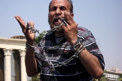 A revolution in chains - a protester demonstrates his feelings outside the Constitutional Court in Cairo.