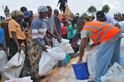 Aid workers fill bags of fortified cereal for new arrivals to the Mugunga camp in eastern DR Congo.