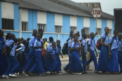School kids crossing busy intersection in Kinshasa, Democratic Republic of Congo.