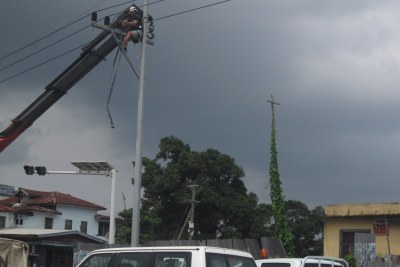 Workers of the Liberia Electricity Corporation planting a metal pole in Monrovia.