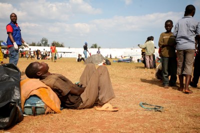A Burundian refugee dozes in the sun at Lake Tanganyika Stadium in Kigoma, which has been turned into a transit site for the refugees