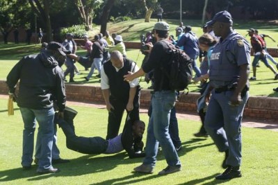 Cette scène cocasse se passe à l'Université de Johannesburg où l'on voit la police malmener un jeune étudiant gréviste.