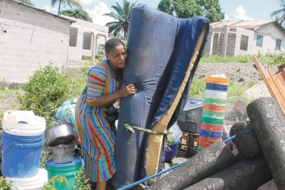 A woman gathering her belongings in Kibamba Mloganzila on the outskirts of Dar es Salaam city.