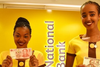 Two attendants display a Chinese currency note and a Kenyan Shilling note during the opening ceremony of a new branch of the National Bank of Kenya which will host a clearing house for Chinese renminbi (RMB) in Nairobi.