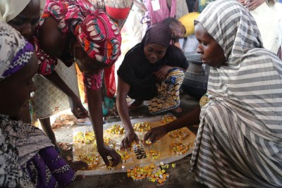 IDP women in one of the camps in Maiduguri, Borno State, Nigeria, collect their share of stock cubes to prepare the day's meal. The women are paid a salary to cook the meals.