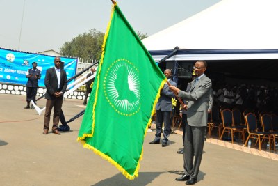 Le Président Kagame portant le drapeau de l' Union africaine.