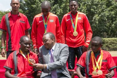 President Uhuru Kenyatta admires Paralympic athlete Henry Kirwa’s medal during a ceremony at State House.