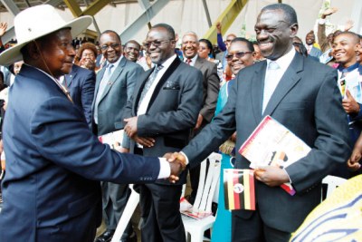 President Museveni (left) shakes hands with his political rival Kizza Besigye (file photo).