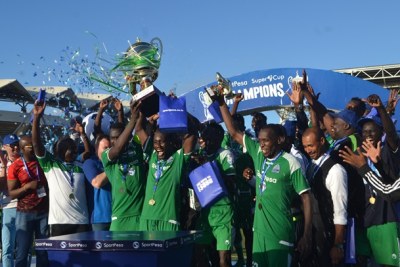 Gor Mahia players and officials celebrate with SportPesa Super Cup trophy and medals after defeating their Kenyan traditional rivals AFC Leopards in a thrilling match final held at the Uhuru Stadium in Dar es Salaam.