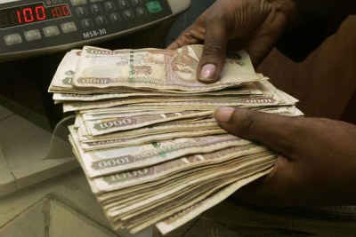 A teller counts money at a Kenyan bank (file photo).