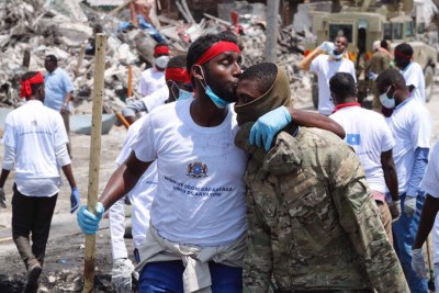 Hundreds of young Somali volunteers arriving at the scene of the explosion to help clean up the debris.