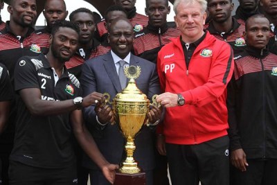 Deputy President William Ruto (centre) with the CECAFA Senior Challenge Trophy at his Karen residence on December 19, 2017 where he hosted the Harambee Stars team.