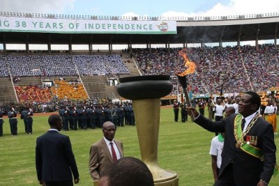 President Emmerson Mnangagwa lights a torch during a celebration marking the nation's 38th independence anniversary.
