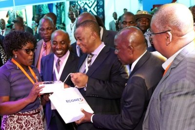 VP Chiwenga receives a present during his tour of the Econet Wireless stand at the ZITF.