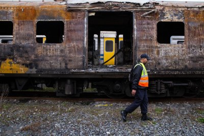 Metrorail official walks passed a charred train carriage in Cape Town last week. It is one of several carriages damaged in arson attacks in recent weeks.