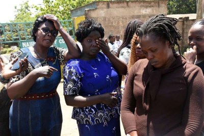 Carolyne Odira (left), Mildred Odira’s mother, Maureen Anyango (right), Mildred’s sister, and other family members outside City Mortuary on February 4, 2019.