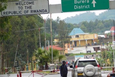 Contrôle à la frontière. Un agent de sécurité rwandais inspecte un véhicule du côté ougandais au poste frontière de Cyanika.
