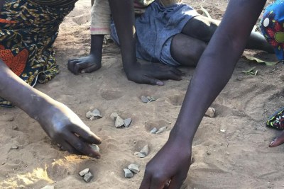 Three girls play the game isolo on the ground in the lead-affected township of Waya in Kabwe. Soil is the main source of lead exposure in Kabwe.