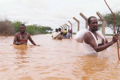 Garissa residents wade through floods after the River Tana burst its banks following days of torrential rain.