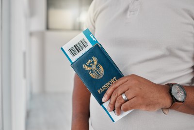 Un homme à l'aéroport avec un passeport, un visa de voyage et un billet pour un vol d'immigration internationale.