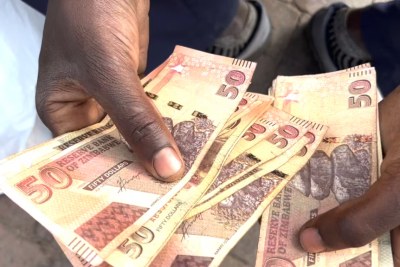 A Zimbabwean holds local currency in Harare on Feb. 13, 2024 (file photo).
