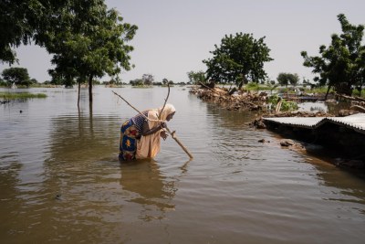 Azimi Abubakar, 50, a resident of Gasamu, wades through the floodwater in Jakusko LGA of Yobe State, Nigeria, on 01 October 2022.